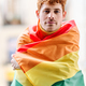 Redheaded gay man wrapping with a rainbow lgbt flag - PhotoDune Item for Sale