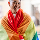 Happy gay man wrapping with a rainbow lgbt flag - PhotoDune Item for Sale