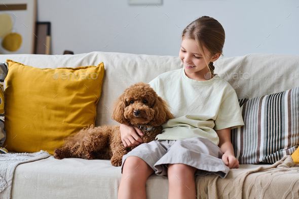 Little girl sitting with her pet at home - Stock Photo - Images