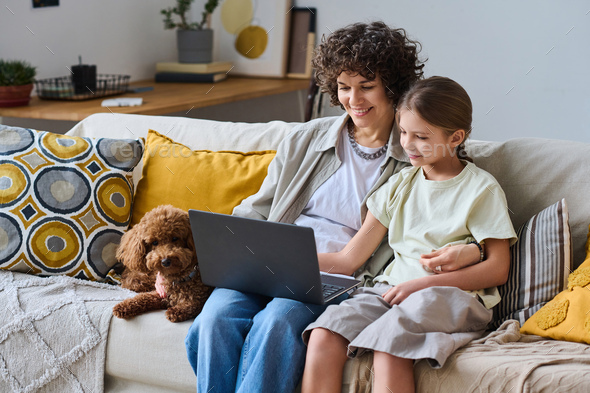 Mom and daughter using laptop at home - Stock Photo - Images
