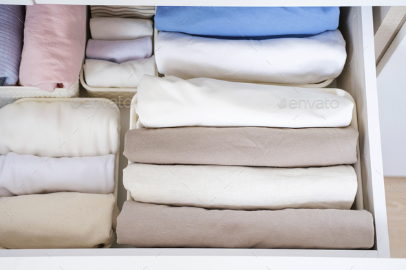 Clothes folded in a box in a dresser close-up, space organization concept.