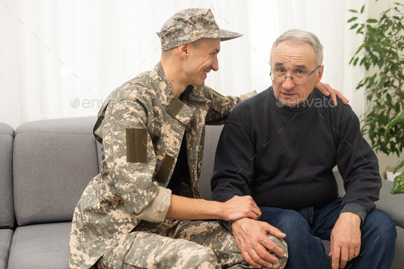 Portrait of army man with parents, elderly father and military son.