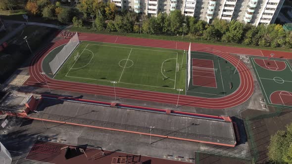 People play sports at the stadium in the yard in the city. Aerial 11 alt