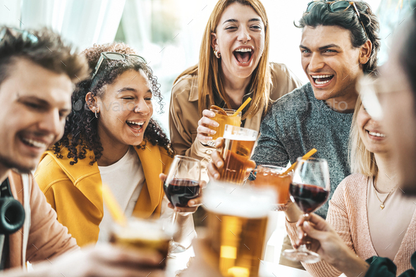 Happy multiracial friends toasting beer glasses at brewery pub Stock Photo  by engy91