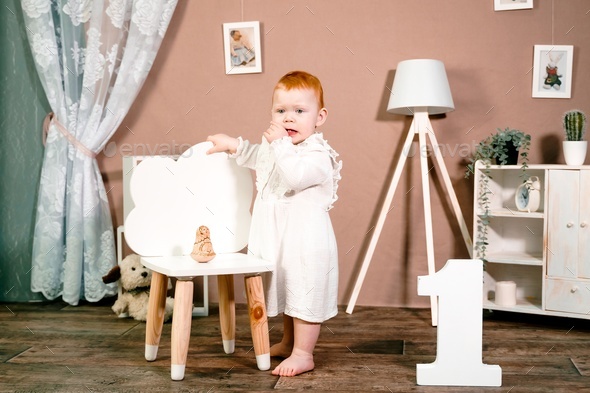 Little redhead baby girl celebrates first birthday anniversary. 1 year family party Professional  - Stock Photo - Images