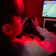 Teenager boy gamer play football gamepad video game console in red gaming room. - PhotoDune Item for Sale