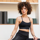Fit woman with curly hair relaxing on yoga mat in studio - PhotoDune Item for Sale