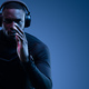 Athletic black guy in headphones running against blue background - PhotoDune Item for Sale