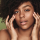 Black woman touching cheeks in studio - PhotoDune Item for Sale
