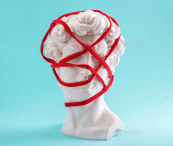 David's head wrapped in red thread on blue background. - Stock Photo - Images