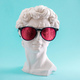 Plaster statue head wearing pink sunglasses on blue background. - PhotoDune Item for Sale