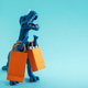 Cute blue dinosaur with orange shopping bags on a blue background.  - PhotoDune Item for Sale