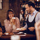 Happy waiter having fun with customers while serving them in a pub. - PhotoDune Item for Sale