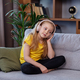 Happy child listens to music or audiobook at home on couch. Little school kid wearing headphones - PhotoDune Item for Sale