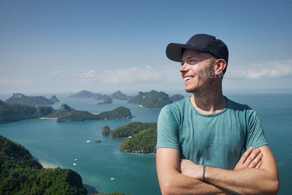 Laughing man on hill against group of islands in sea - Stock Photo - Images