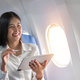 Beautiful asian travel woman watching movie on digital tablet in airplane - PhotoDune Item for Sale
