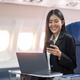 Traveling and technology. Flying at first class. Pretty young business woman using smartphone while - PhotoDune Item for Sale