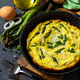 Egg omelet with asparagus and onions in a cast iron skillet. - PhotoDune Item for Sale