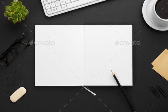 Top View of Blank Paper in Note Book Surrounded By Office Supplies On Gray Desk - Stock Photo - Images