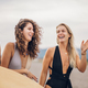 Portrait of a three attractive woman friends walking with surfboard on a beach - PhotoDune Item for Sale