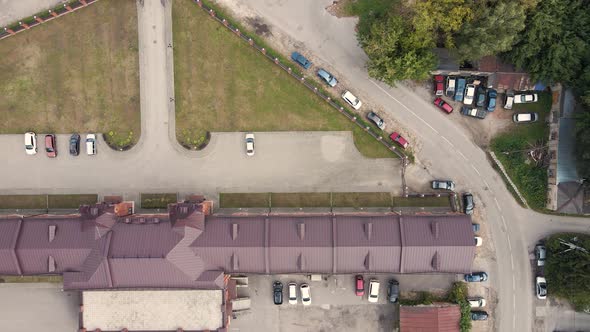 Aerial View of a City Street with Green Trees Houses and Standing Cars alt