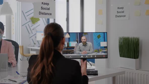 Back View of Business Woman with Face Mask Disscusing on Videocall Conference alt