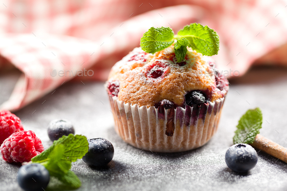 Freshly baked muffins with powdered sugar and fresh berries - Stock Photo - Images