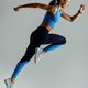 Determined sporty woman running in Mid-Air exercising during cardio workout over studio background - PhotoDune Item for Sale
