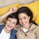 Portrait of happy woman with son, mother and boyfriend smiling and looking at camera lying together - PhotoDune Item for Sale