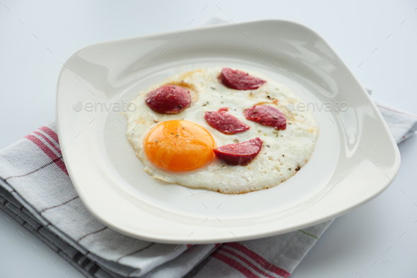 fried egg mixed with sausage on a plate  - Stock Photo - Images