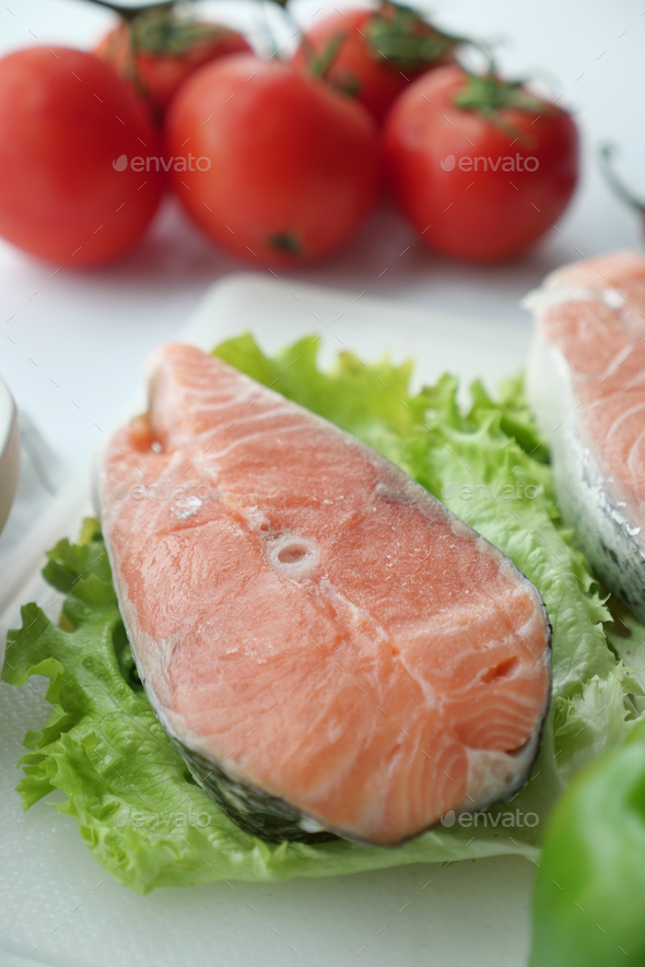 Raw, fresh salmon steak and tomato on table  - Stock Photo - Images