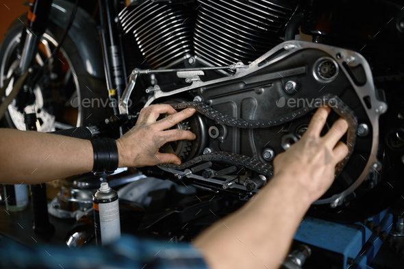 Man mechanic fixing motorcycle engine working at garage workshop