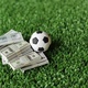 Selective focus image of soccer football and money on field. - PhotoDune Item for Sale