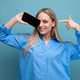 smiling attractive blond girl showing blank smartphone screen with mockup for web page on blue - PhotoDune Item for Sale