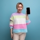 attractive blond woman in a casual look demonstrates a smartphone screen mockup on a blue background - PhotoDune Item for Sale