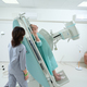 Medical technician standing near X-Ray machine while helping for man - PhotoDune Item for Sale