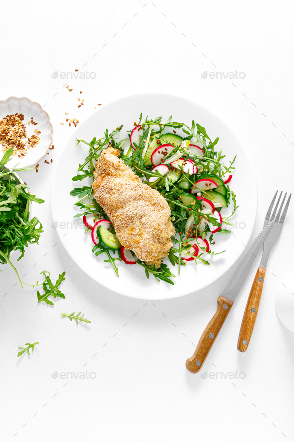 Chicken fillet baked in breadcrumbs and fresh vegetable salad of radish and cucumber. Top view - Stock Photo - Images