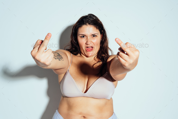 Plus size woman posing for body acceptance Stock Photo by oneinchpunchphotos