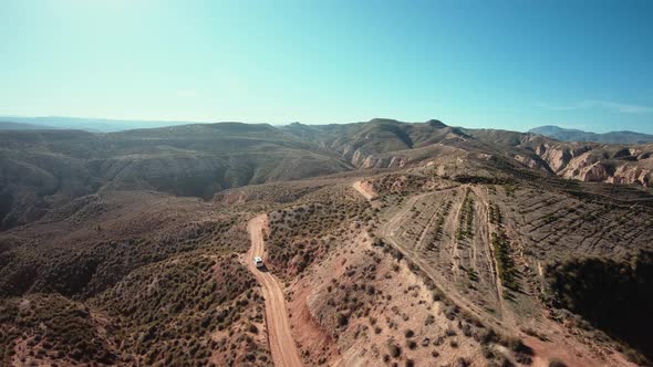 Aerial Shot of Camping Van on Gravel Mountain Road alt