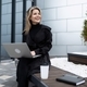 stylish business woman during a break drinking coffee on the street with a laptop in her hands - PhotoDune Item for Sale