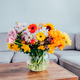 Vase with huge multicolor various flower bouquet on the coffee table in modern cozy living room  - PhotoDune Item for Sale