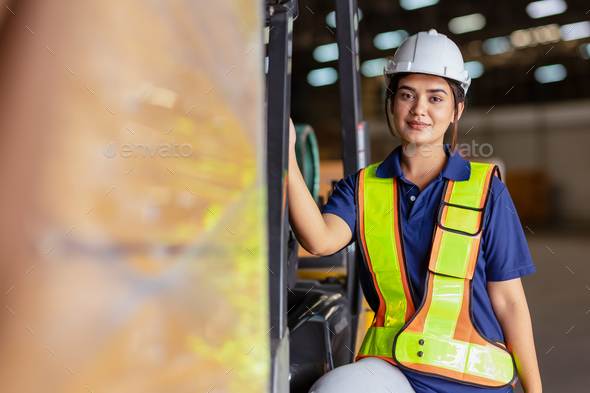 Indian woman staff worker engineer supervisor in safety suit work in factory warehouse