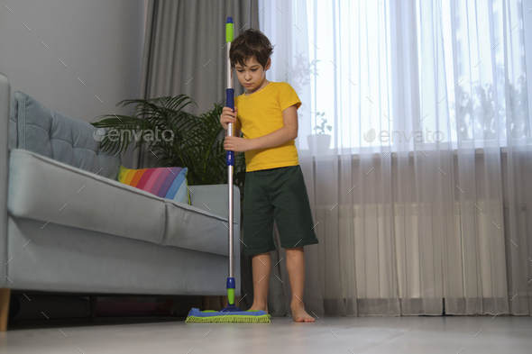 sad boy hugging a mop, parents make him clean up. boy washes the floor and helps parents clean the