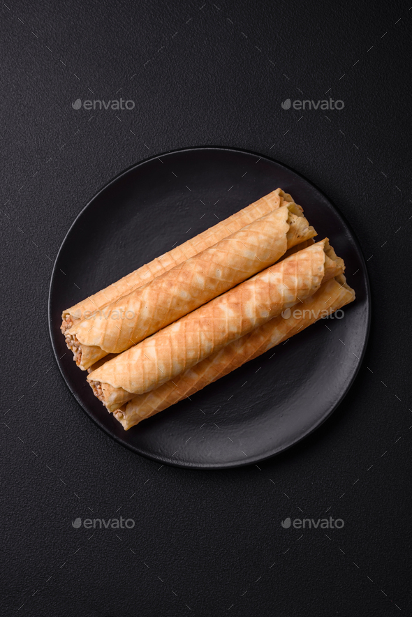 Delicious crispy wafer rolls with cream filling with nuts Stock Photo