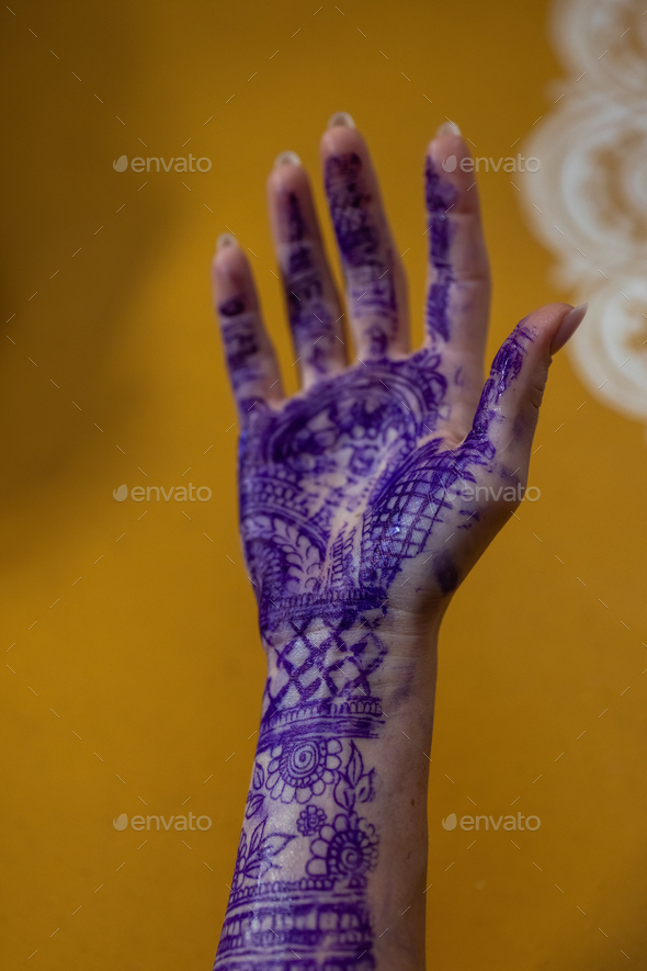 Applying Beautiful henna art on hands. Bridal design. Wedding Mehendi.