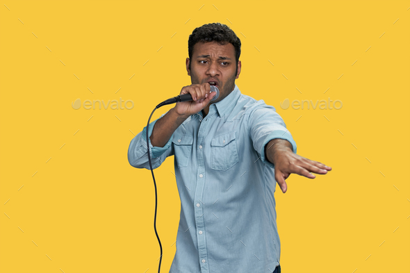 Portrait of a young indian singer with microphone.