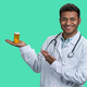 Portrait of male indian doctor holding orange medicine bottle. - PhotoDune Item for Sale
