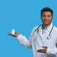 Portrait of male indian doctor holding white medicine bottle. - PhotoDune Item for Sale