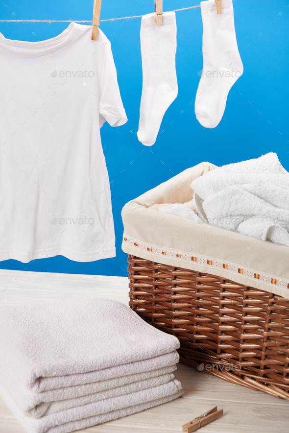 Laundry basket filled white fluffy towels, cotton flowers and a bottle of  liquid soap against a blurred grey background Stock Photo - Alamy