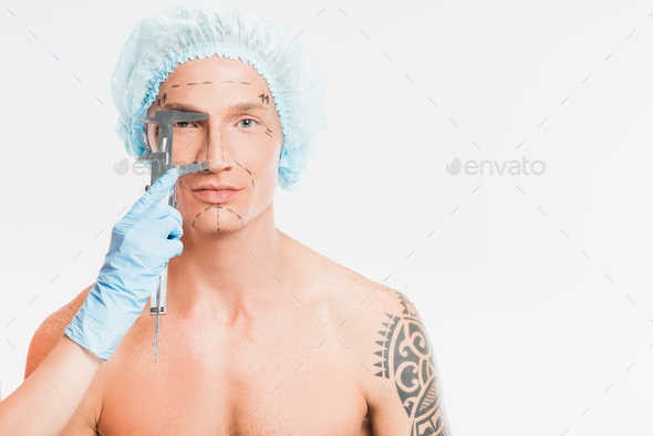 doctor hands measuring man face with drawn marks isolated on white